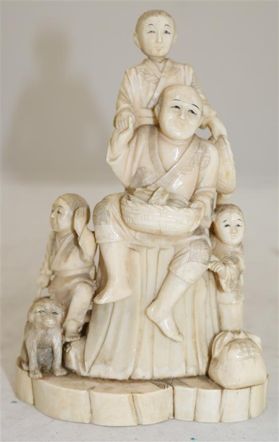 A Japanese walrus ivory okimono of a family, early 20th century, 16.8cm